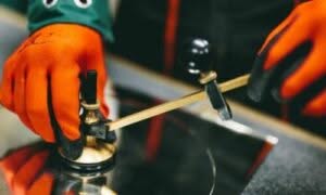 vetraio Roma che con uno strumento taglia uno specchio rotondo